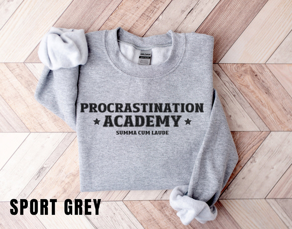 a grey sweatshirt with the words procrastination academy on it