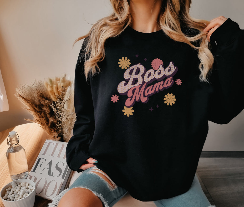 a woman wearing a black boss mama sweatshirt