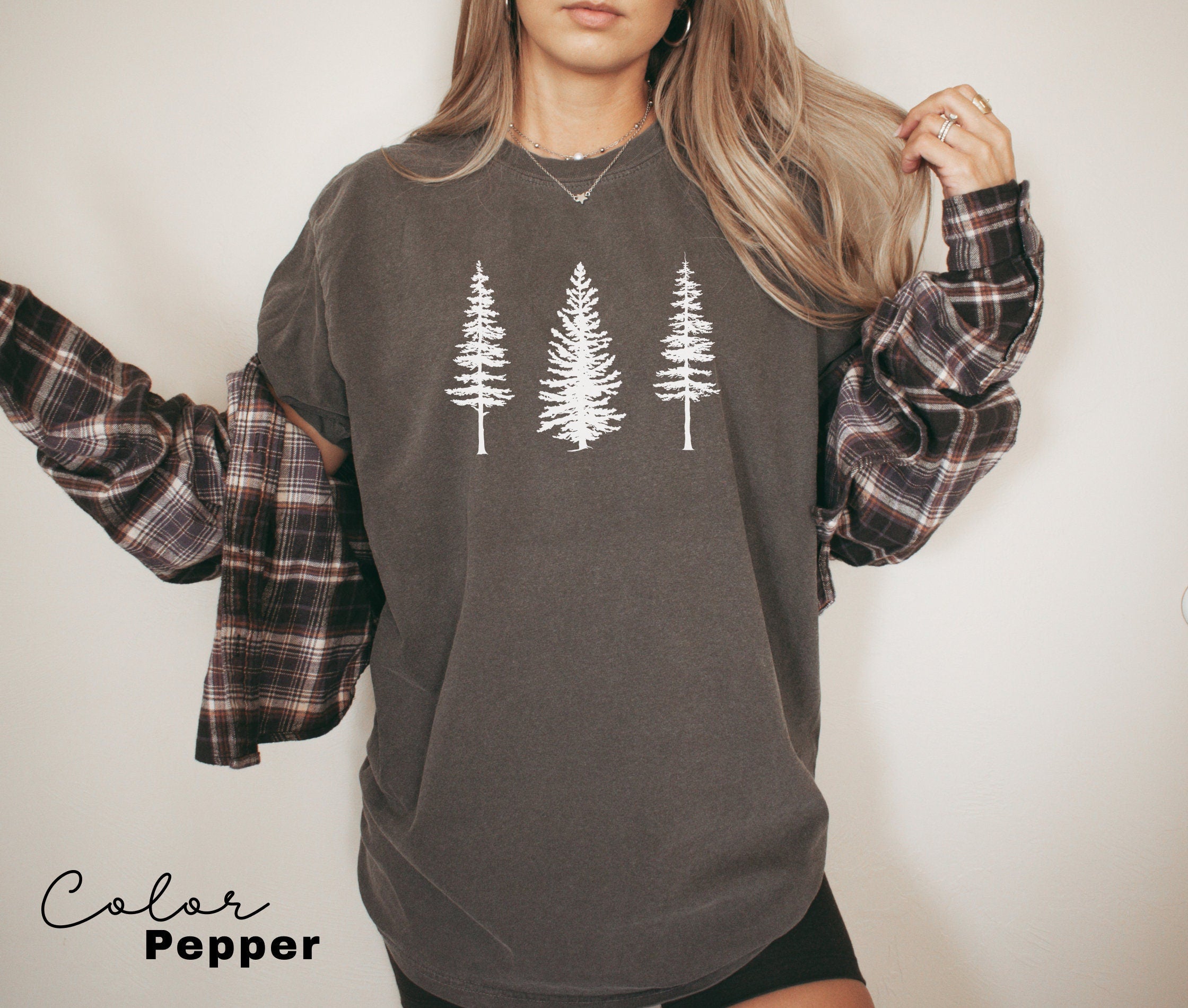 a woman wearing a sweatshirt with trees on it