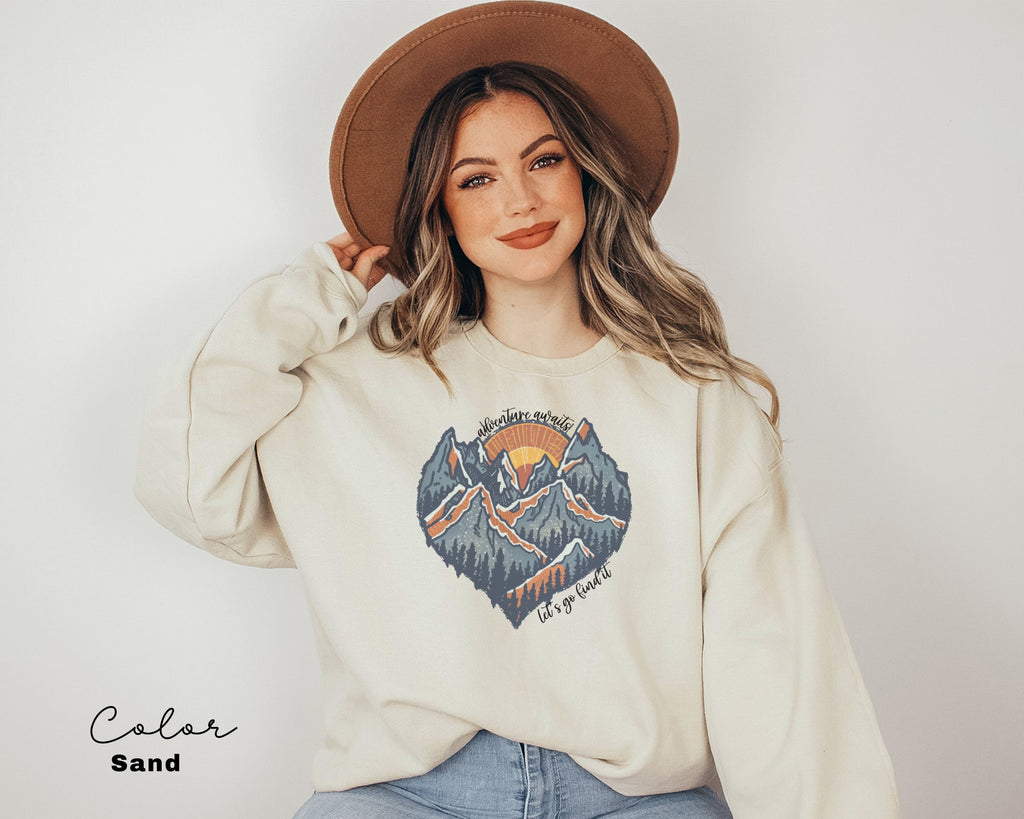 a woman wearing a sweatshirt with a mountain scene on it