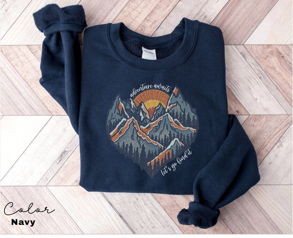 a blue sweatshirt with a mountain scene on it