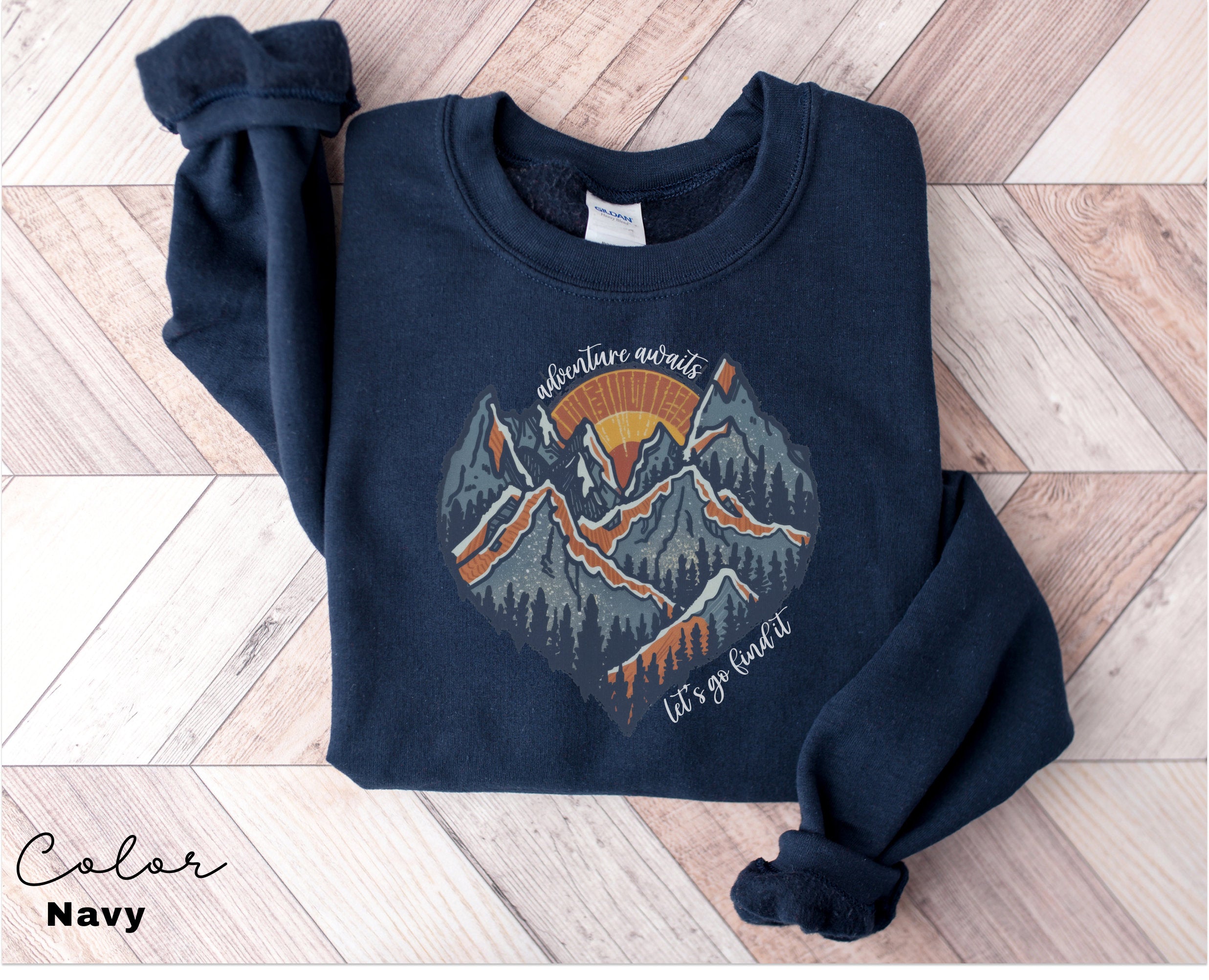 a blue sweatshirt with a mountain scene on it