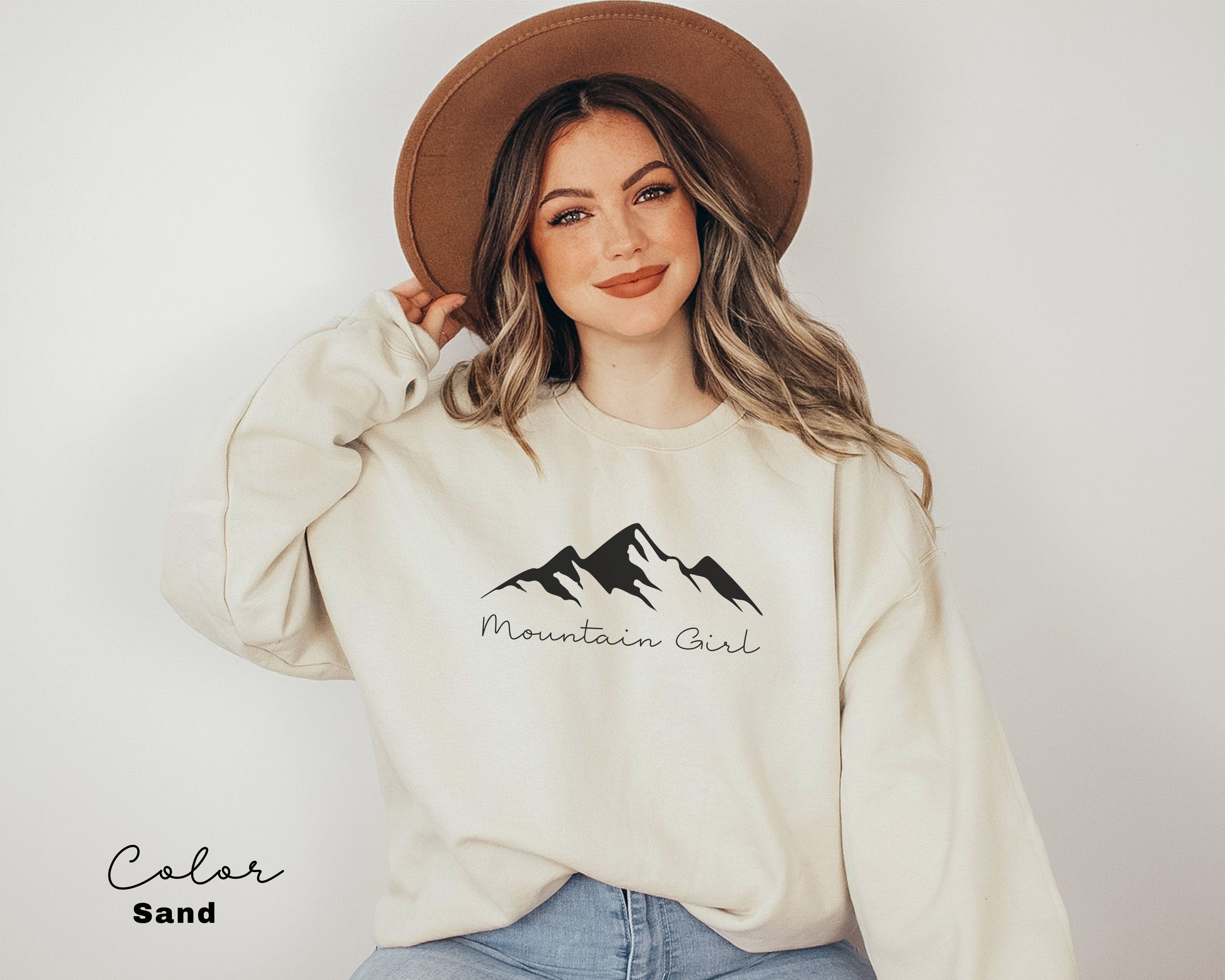 a woman wearing a mountain girl sweatshirt