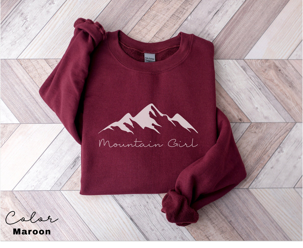 a maroon sweatshirt with the mountain girl logo on it