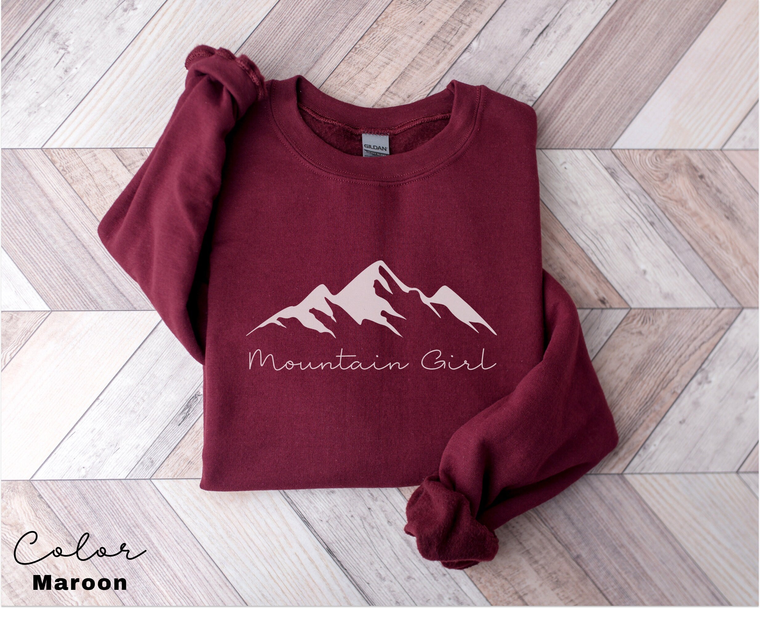 a maroon sweatshirt with the mountain girl logo on it