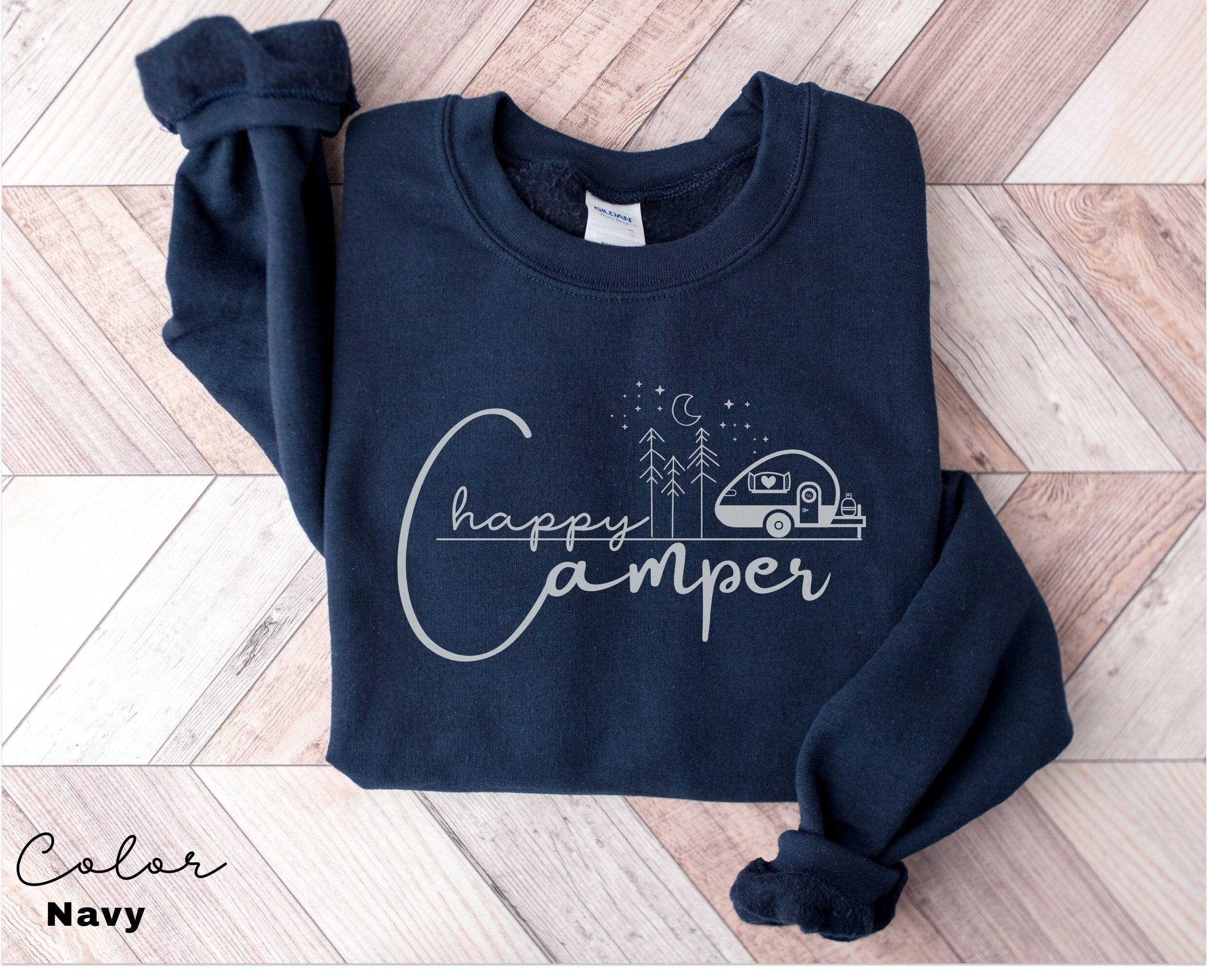 a sweatshirt with a camper on it sitting on a wooden floor