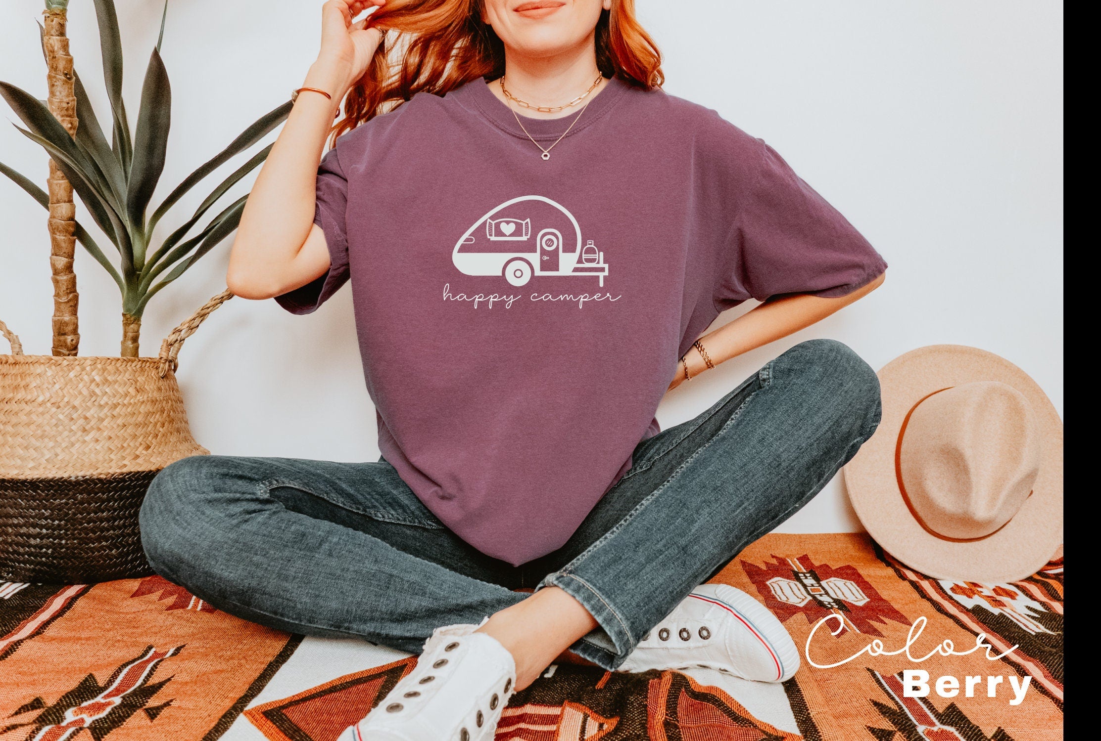 a woman sitting on the floor wearing a happy camper t - shirt