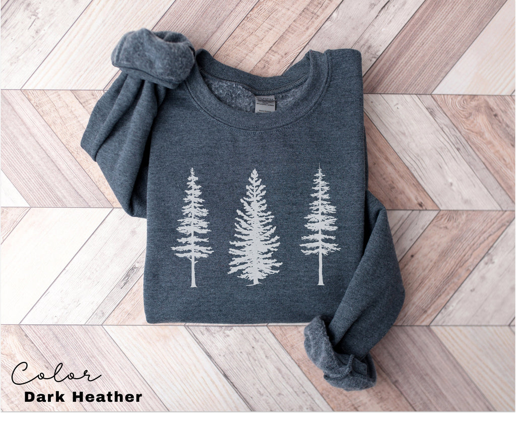 a sweater with trees on it sitting on a wooden floor