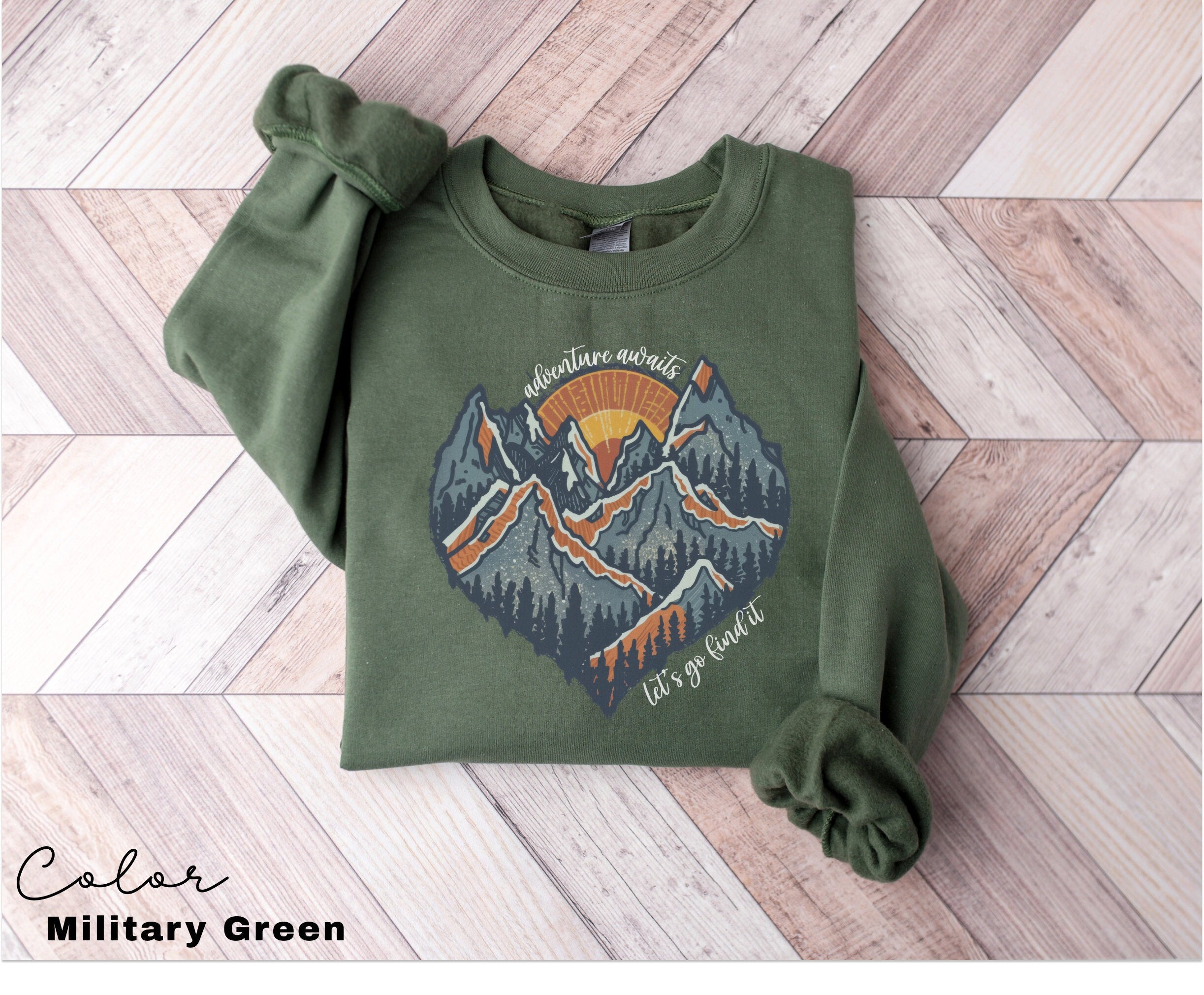 a green sweatshirt with a mountain scene on it