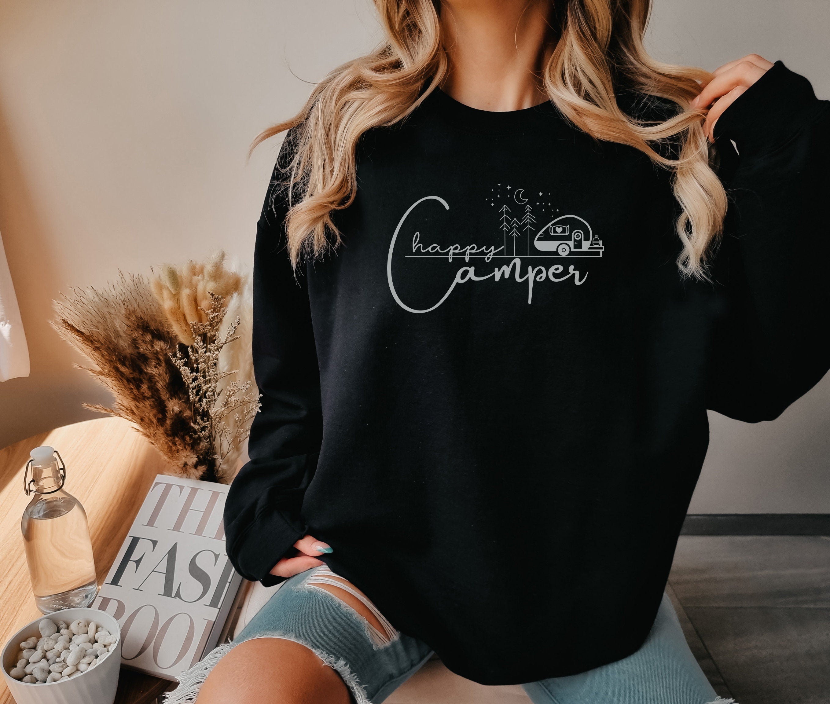 a woman wearing a black camper sweatshirt