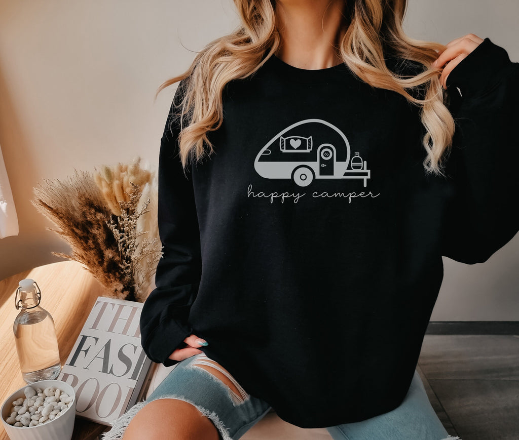 a woman wearing a black happy camper sweatshirt