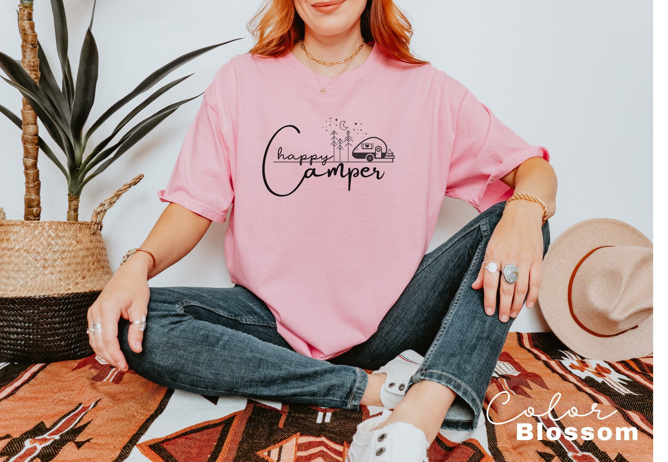 a woman sitting on the floor wearing a pink shirt