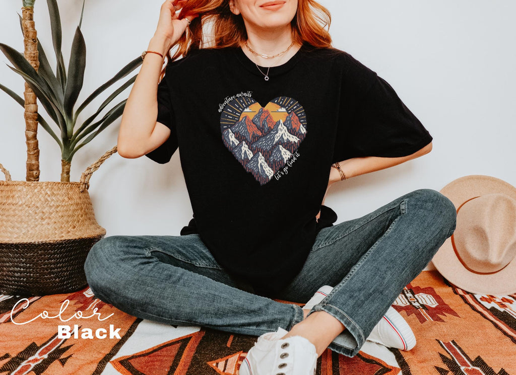 a woman sitting on the floor wearing a black heart t - shirt