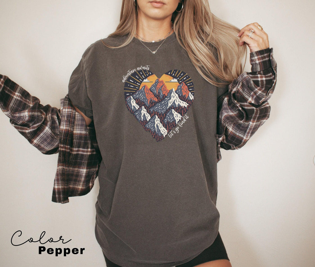 a woman wearing a sweatshirt with a mountain heart on it