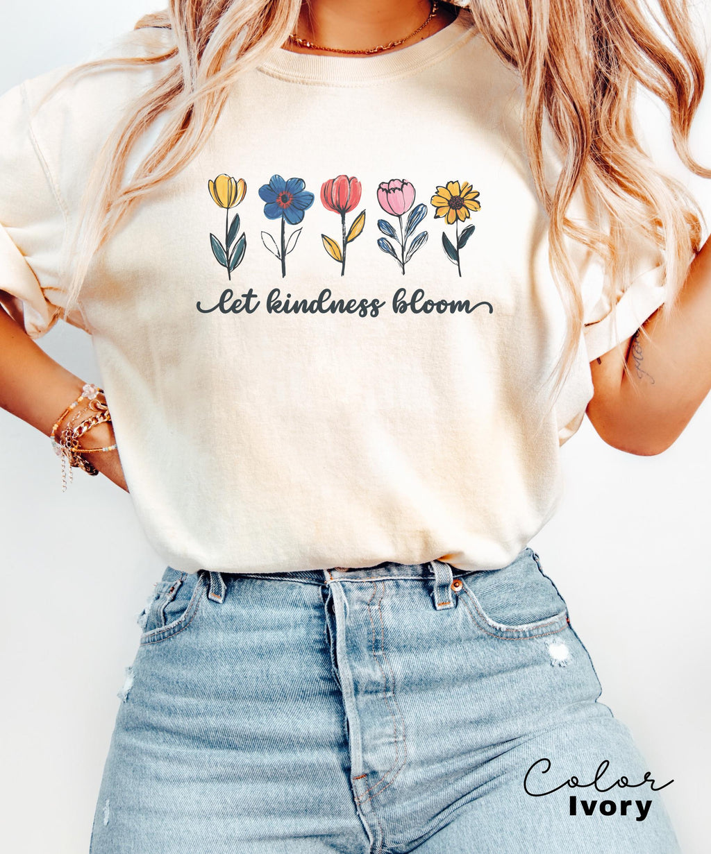 a woman wearing a t - shirt that says let kindness bloom