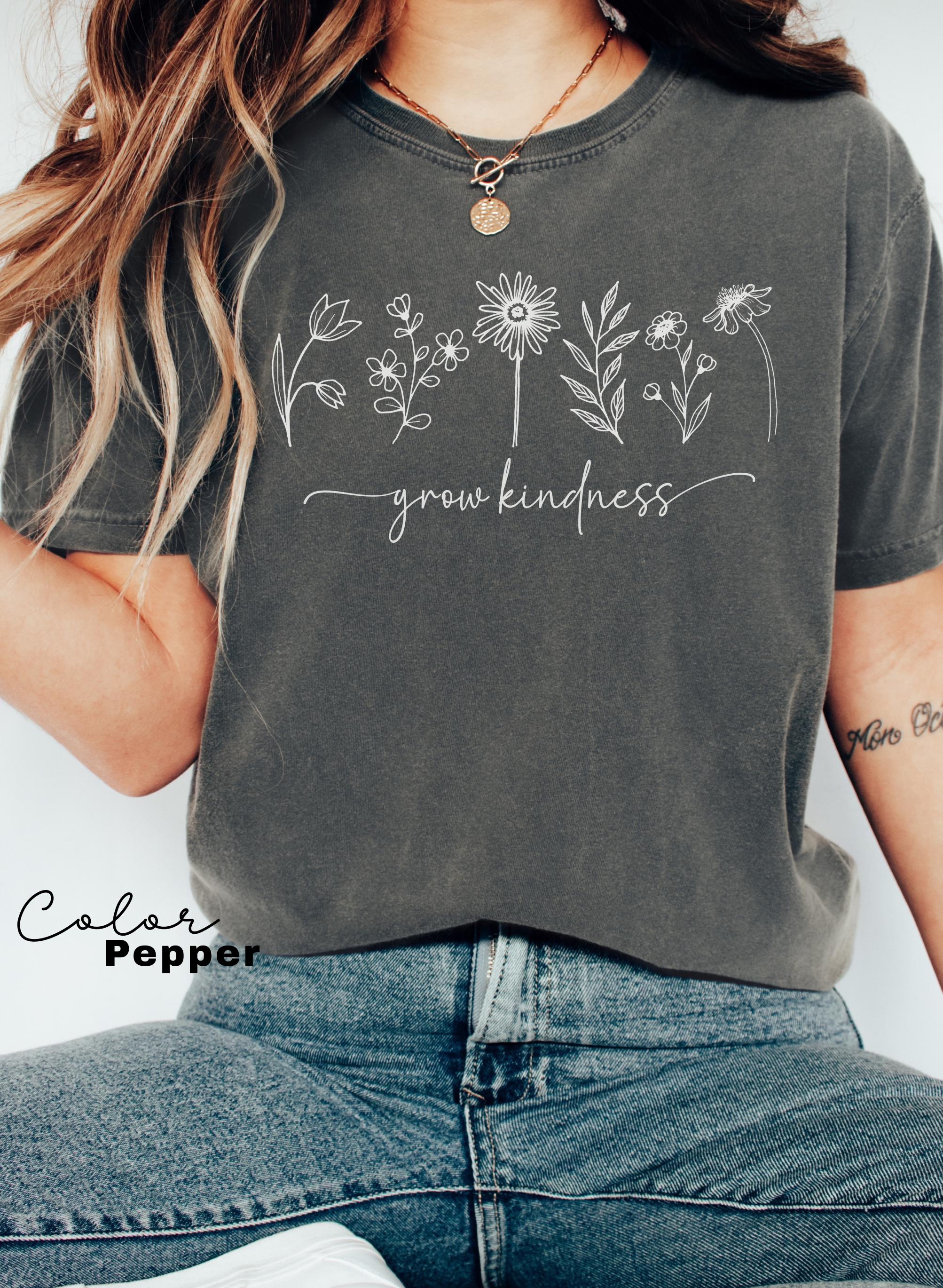 a woman wearing a t - shirt that says grow happiness