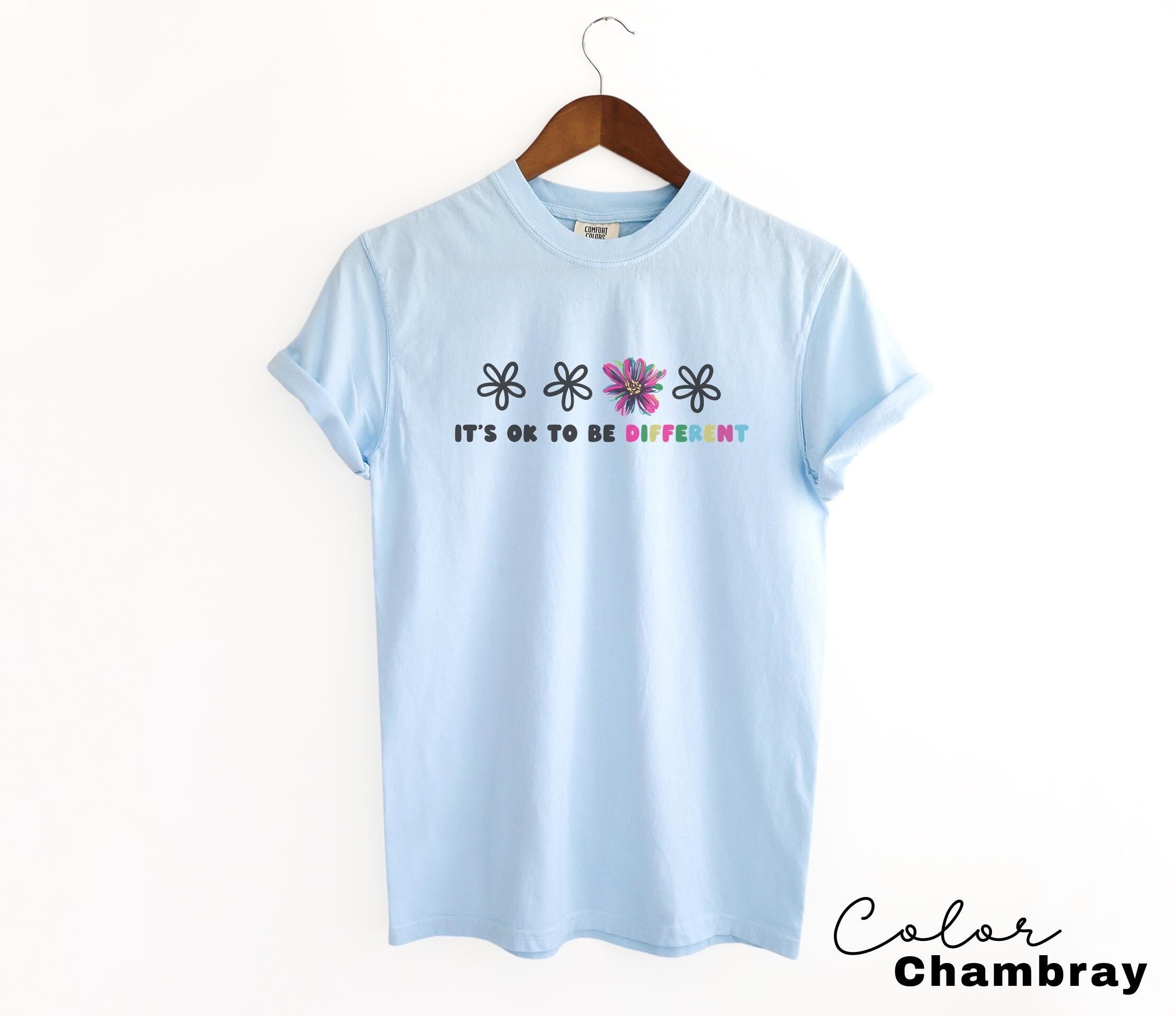 a light blue t - shirt that says it's ok to be different