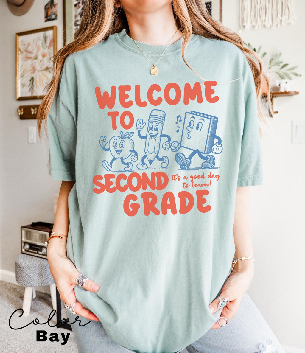 a woman wearing a welcome to second grade tshirt