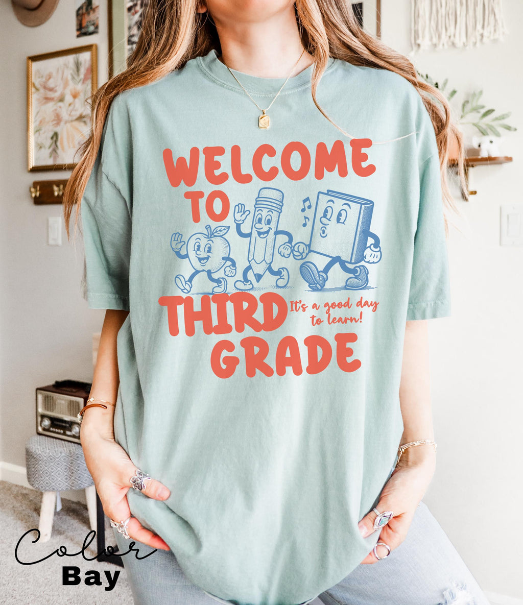 a woman wearing a t - shirt that says, welcome to third grade