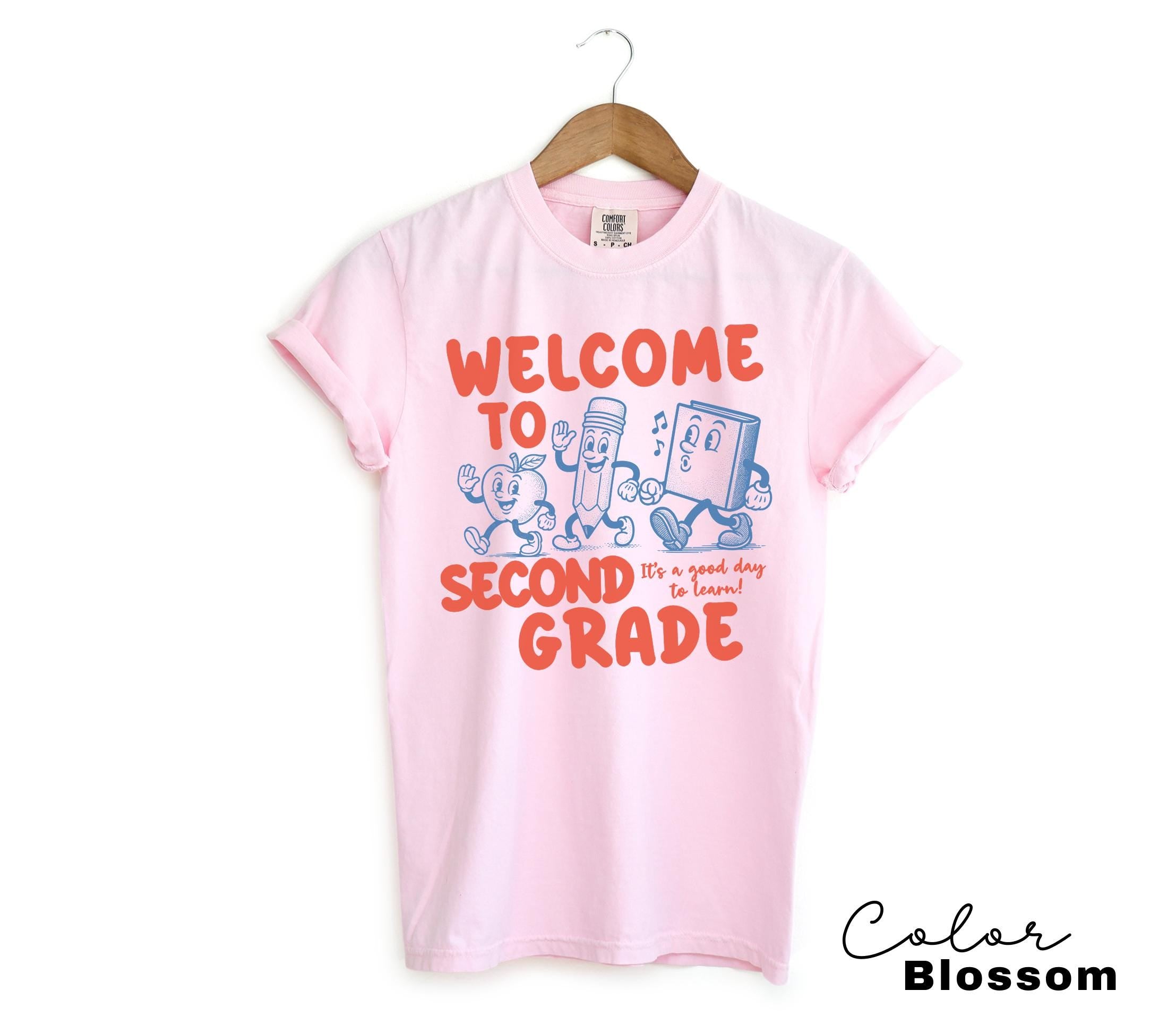 a pink shirt that says welcome to second grade