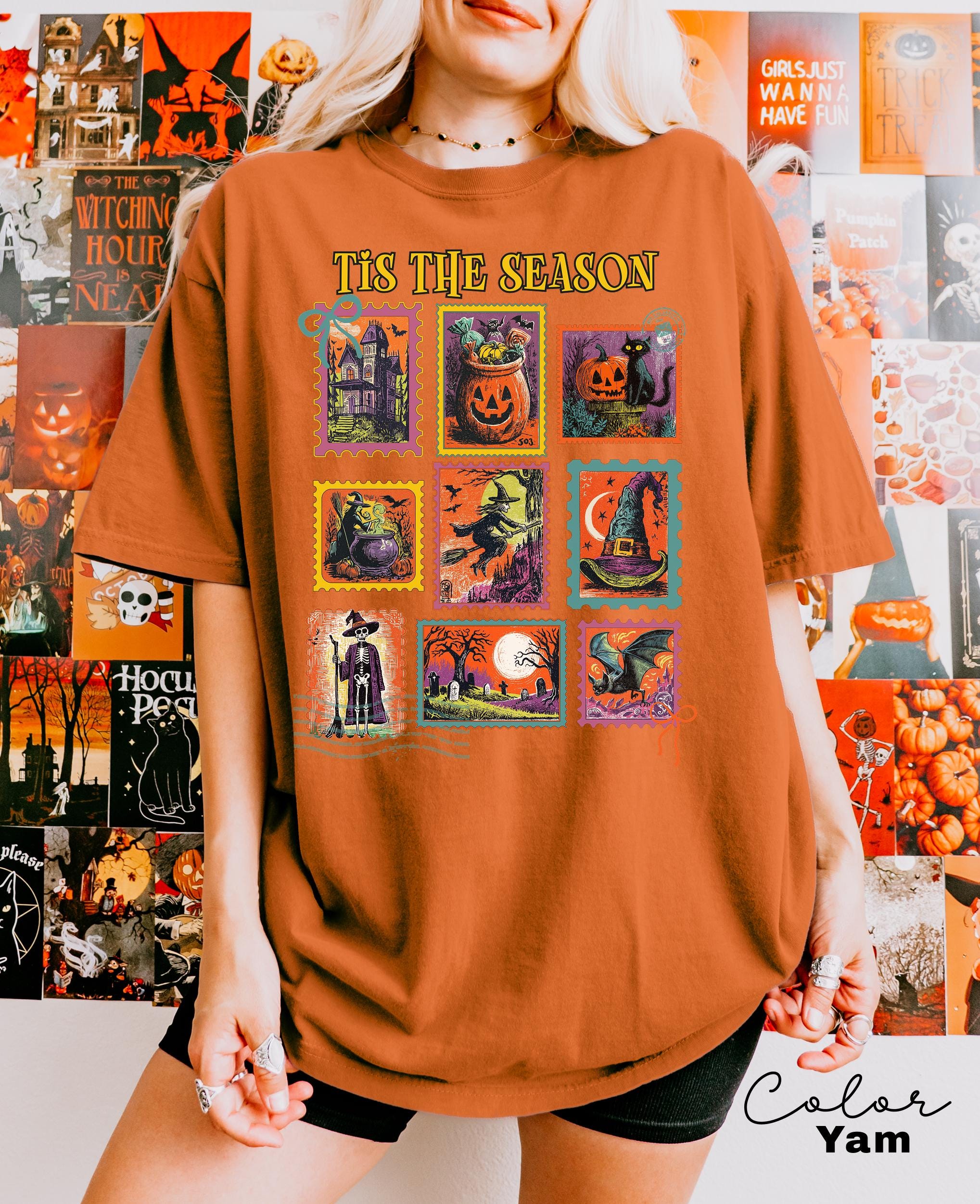 A person wearing a t-shirt with a collage of Halloween-themed illustrations, including pumpkins, bats, and other spooky and festive elements.