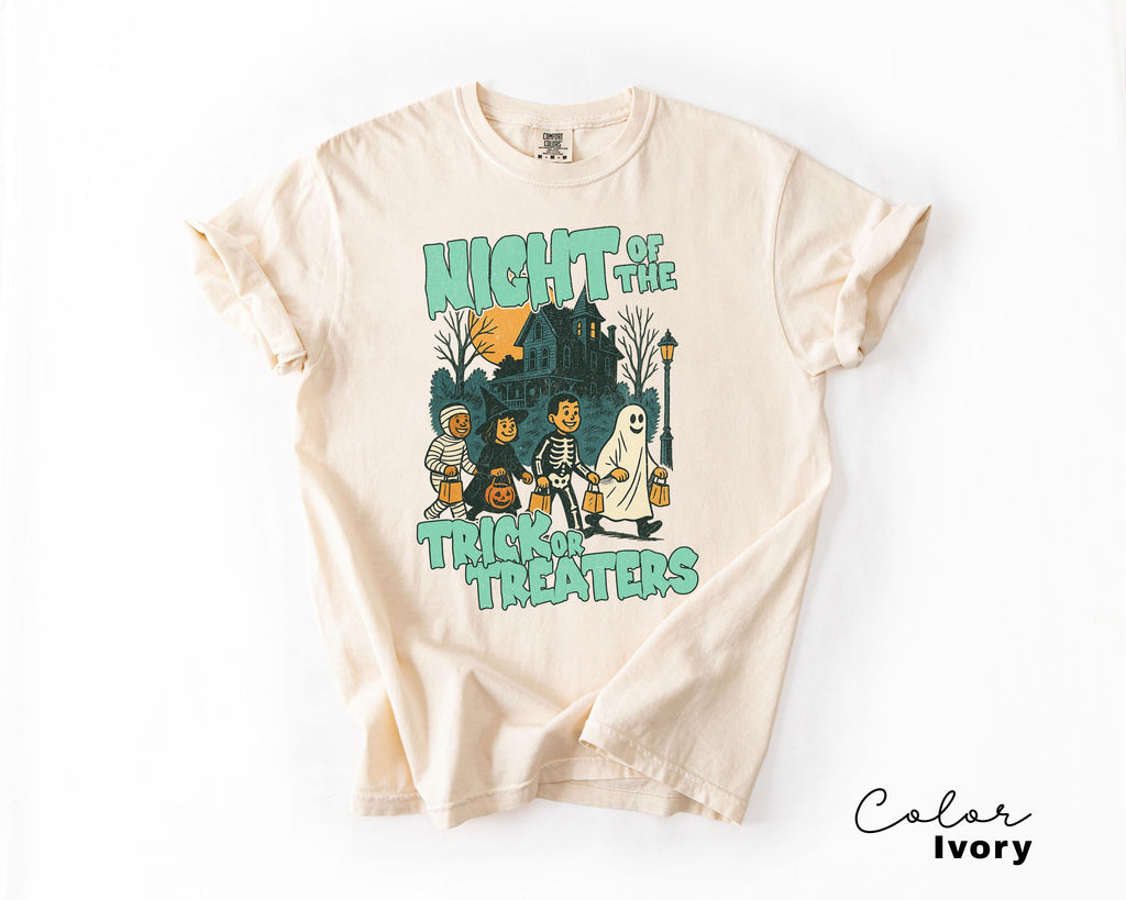 A t-shirt with a Halloween-themed graphic design featuring a skeleton, ghost, and other spooky characters.