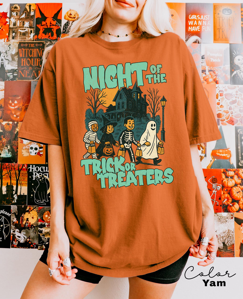 A person wearing a t-shirt with a Halloween-themed graphic design, including silhouettes of people and a ghost.