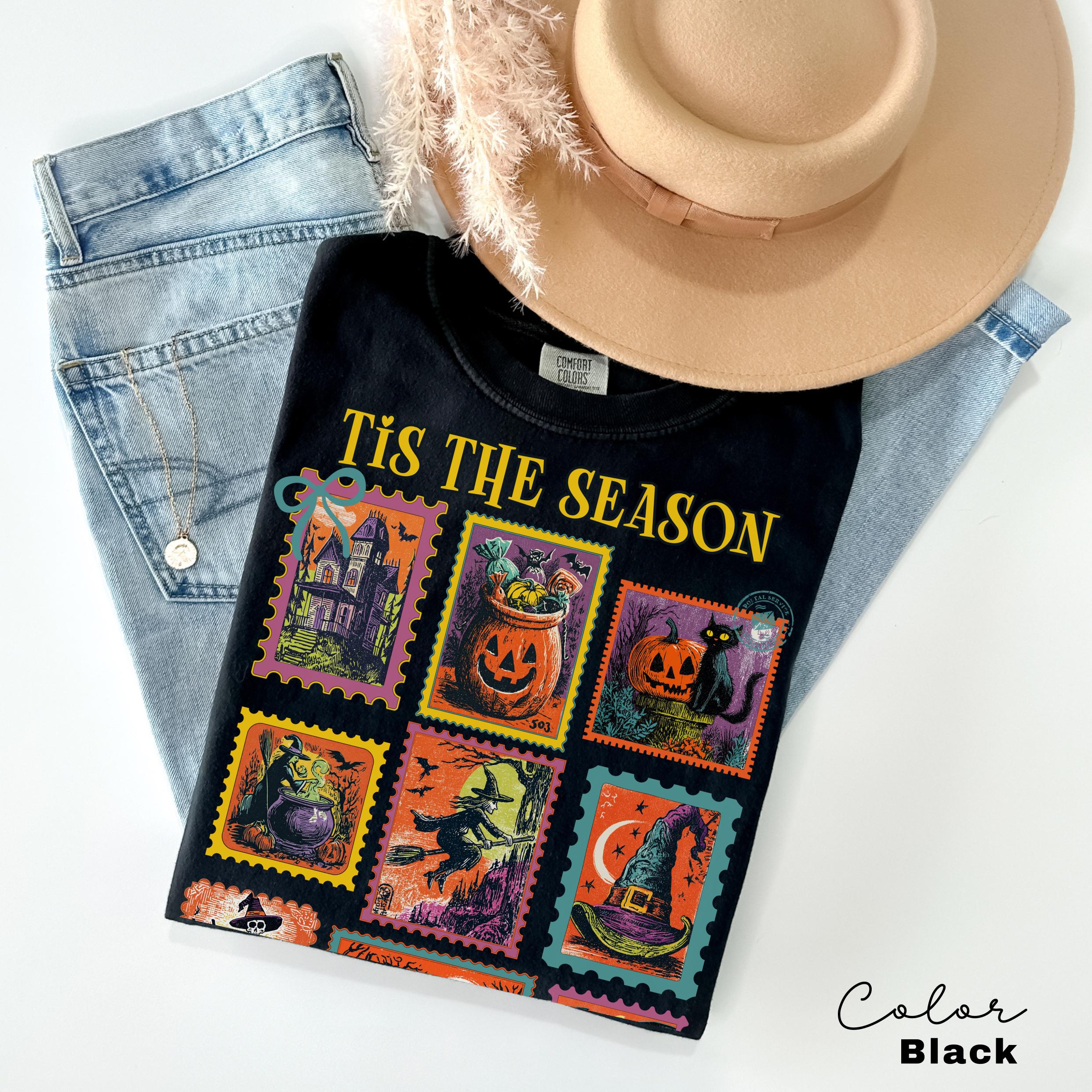 a black t-shirt with a Halloween-themed design, a pair of jeans, and a beige hat.